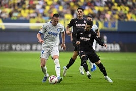 Kike García y Baena luchan por el balón.