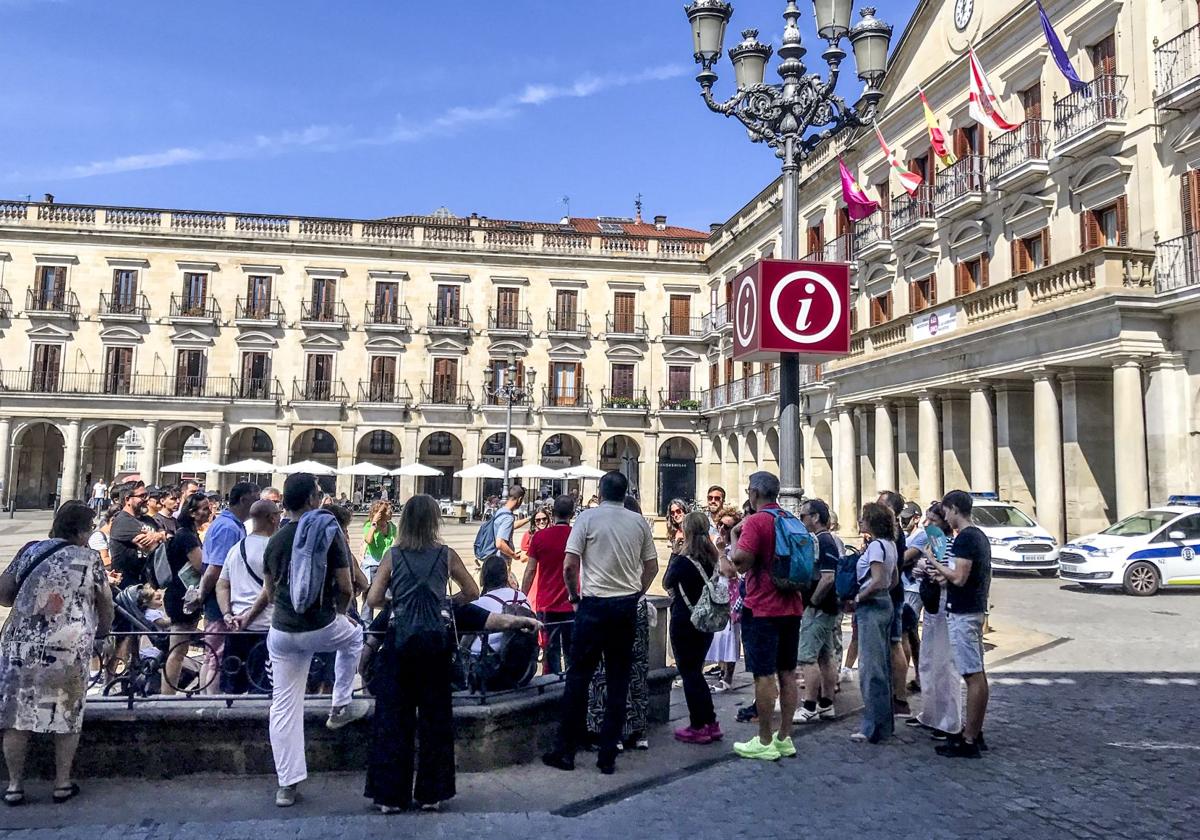 Un grupo de turistas escuchan las explicaciones en la plaza de España.