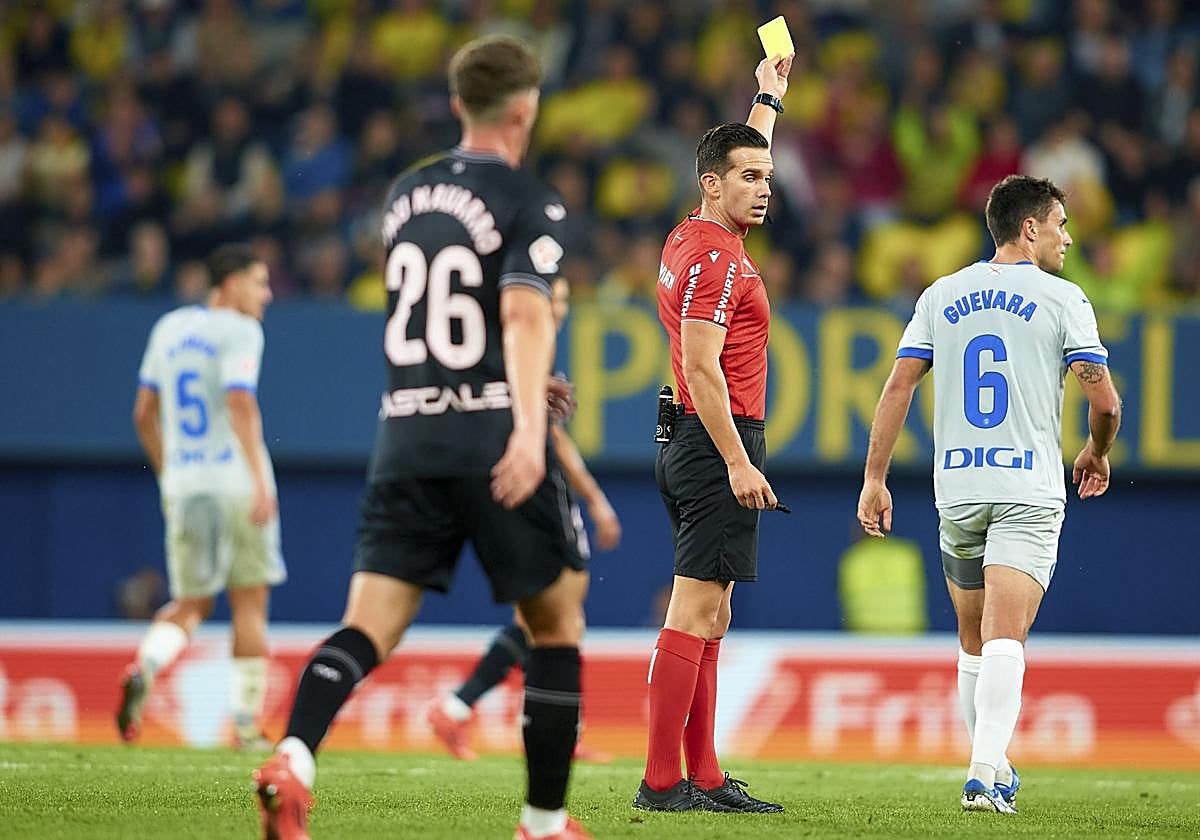 Quintero González muestra a Ander Guevara una de las cuatro amarillas que sacó a lo largo del partido.