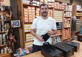 El joven Txaber Arrilaga muestra las zapatillas de su comercio Sillero.