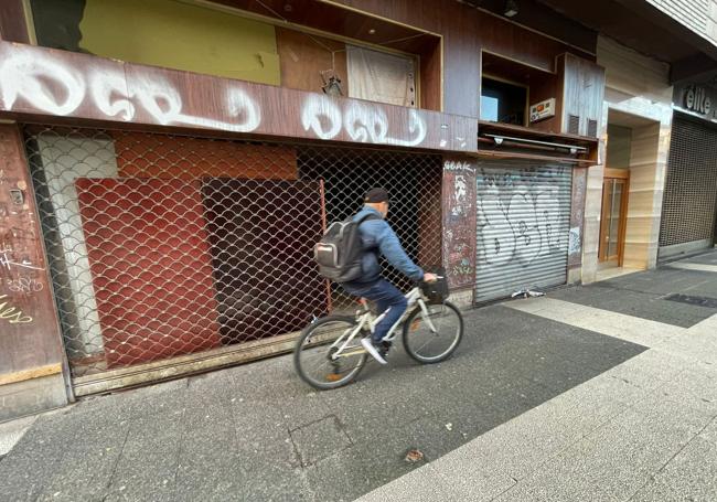 Un ciclista pasa frente a la lonja, ya cerrada, que hasta ahora estaba 'okupada'.