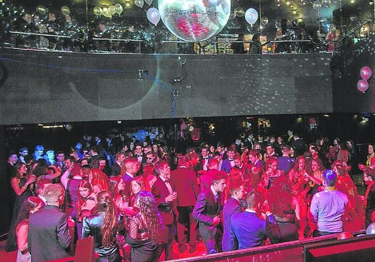 Un grupo de jóvenes disfruta del cotillón en la sala de una discoteca.