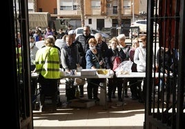 Un grupo de afectados por la DANA espera para recoger la comida caliente del día.