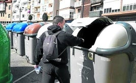 Un vecino deposita la basura en uno de los contenedores grises instalados en Ondarroa.