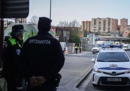 Un agente de la Policia de Basauri y otro de la Ertzaintza, junto a la parada del Bizkaibus.