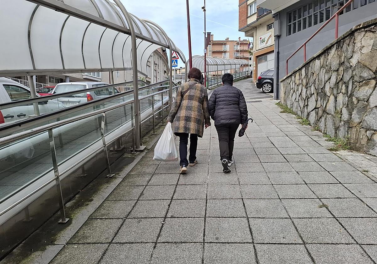 Dos vecinas de Ongarai y Errebalburu suben la cuesta junto a la rampa.