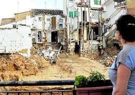 Una mujer observa varias casas dañadas en la localidad valenciana de Chiva.