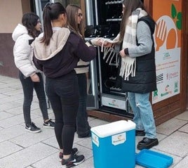 Alumnas del instituto de Etxebarri introducen platos en la maquina expendedora de recuperación de alimentos