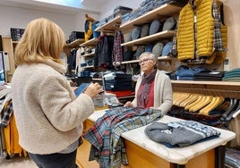 Una clienta se dispone a canjear un bono en un tienda de ropa de caballero.