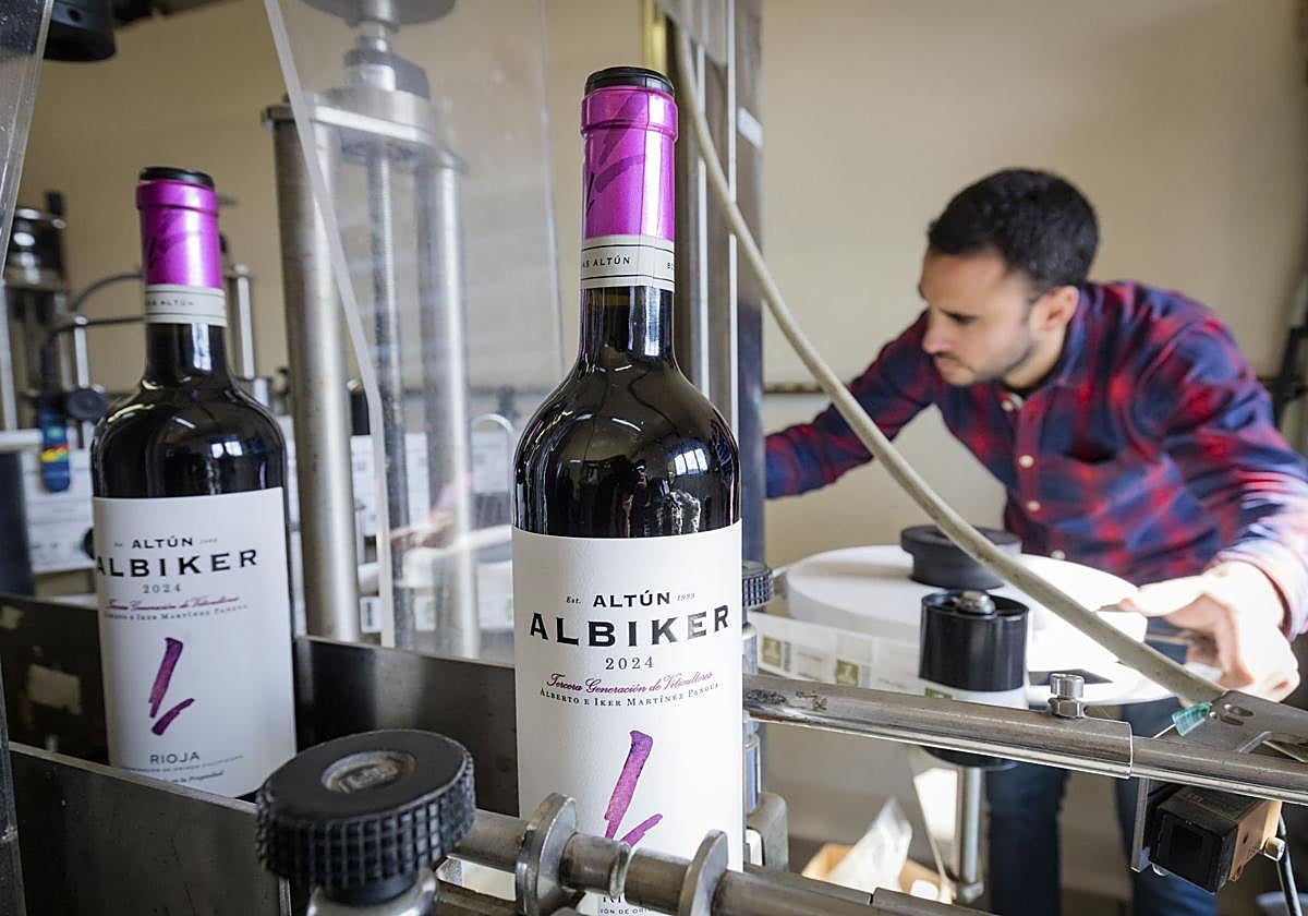 Iker controla el correcto funcionamiento de la máquina que etiqueta todas las botellas que saldrán al mercado.