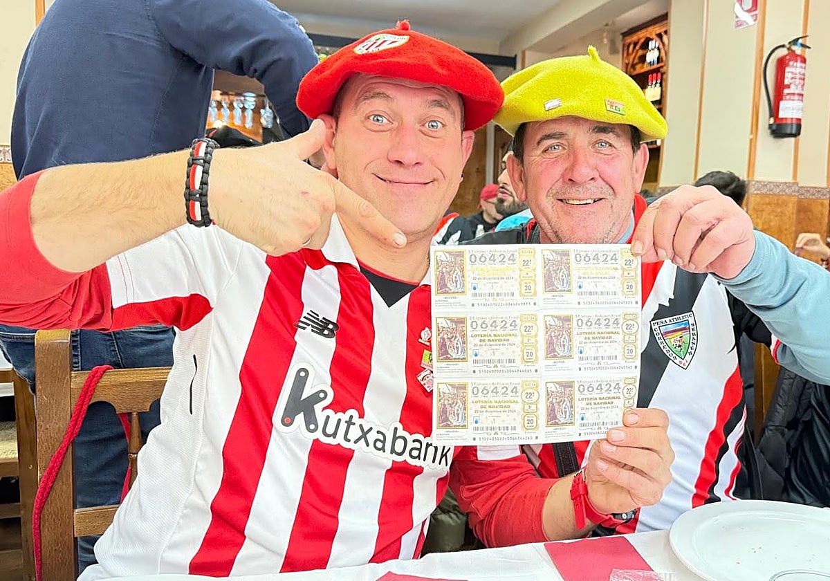 Félix Ribadulla, derecha, junto a otro peñista del Athletic con algunos décimos el domingo en una comida de confraternización en Vallecas.