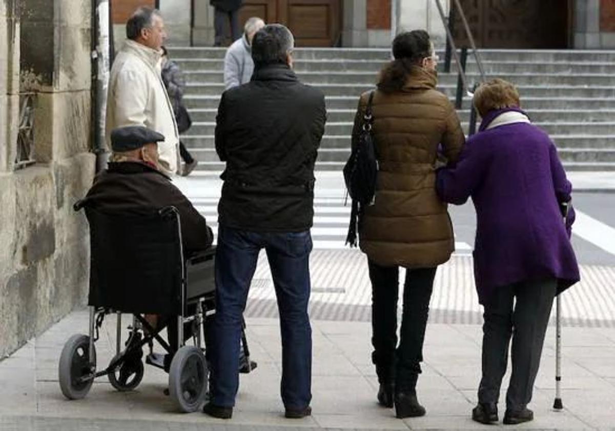 Cuidadores atienden a personas dependientes en la calle.