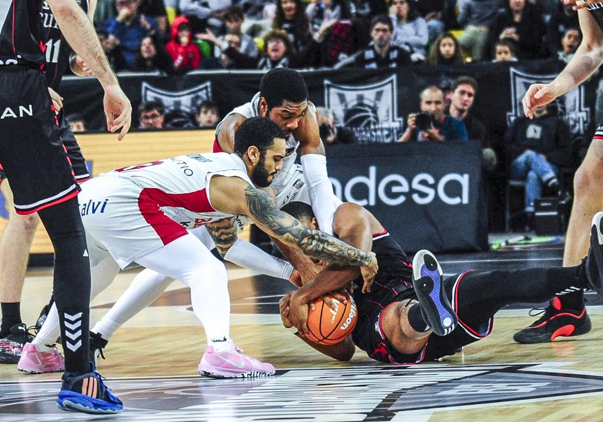 Howard y Forrest tratan de arrebatarle el balón a Pantzar, que se resiste desde el suelo.