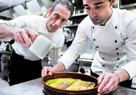 Sergio Ruiz, a la derecha, de Marisquería Serantes, prepara una ración de bacalao al pil-pil.