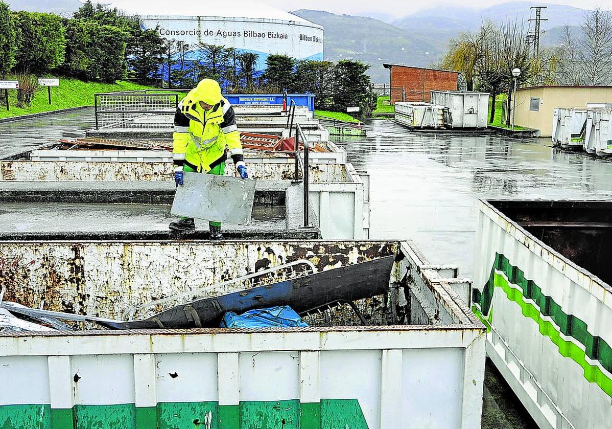 Un operario arroja desechos a un contenedor del garbigune de Santurtzi.