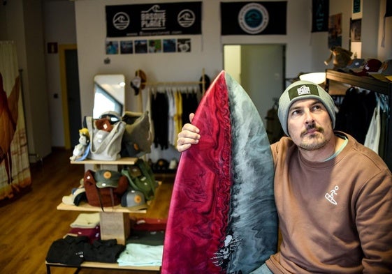 Gonzalo Astorqui posa, tabla en mano, en su nueva tienda de Getxo de estilo surfero llena de moda local.