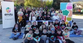 Niños y niñas de la escuela pública de Orduña y los organizadores del evento posan junto al cartel y al lema de este año.