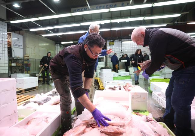 Varios trabajadores en un puesto de pescados de Mercabilbao.