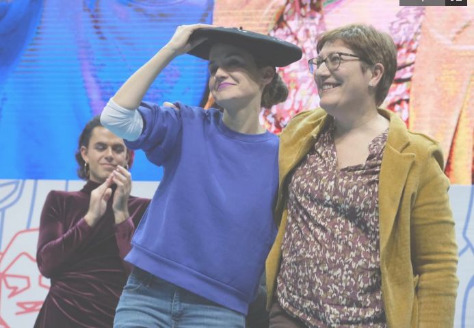 Alaia se calza la txapela, con Aner Peritz aplaudiendo justo detrás.