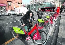 Una usuaria del servicio municipal ancla una bicicleta en el punto de préstamo situado junto a la facultad de Sarriko.