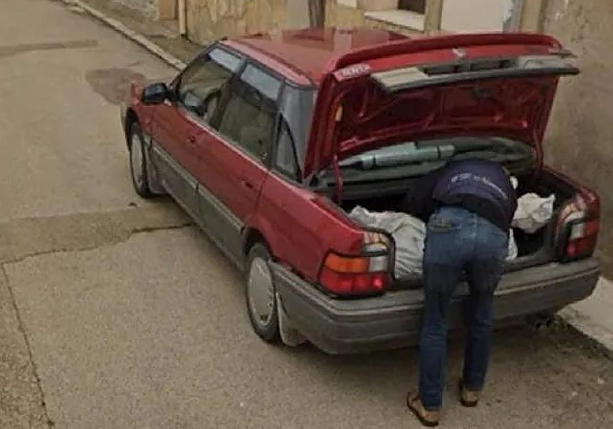 Imagen del hombre con lo que parece un cadáver en el maletero de un coche.