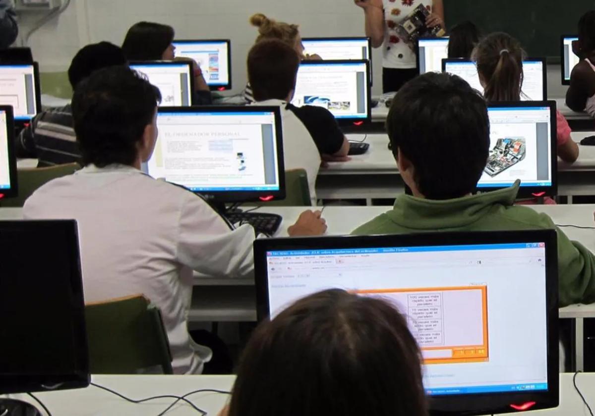 Alumnos en un aula con ordenadores.