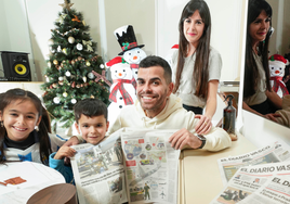 Álex y Usoa posan con sus hijos Elaia y Liam, en el salón de su casa con la decoración navideña de fondo.