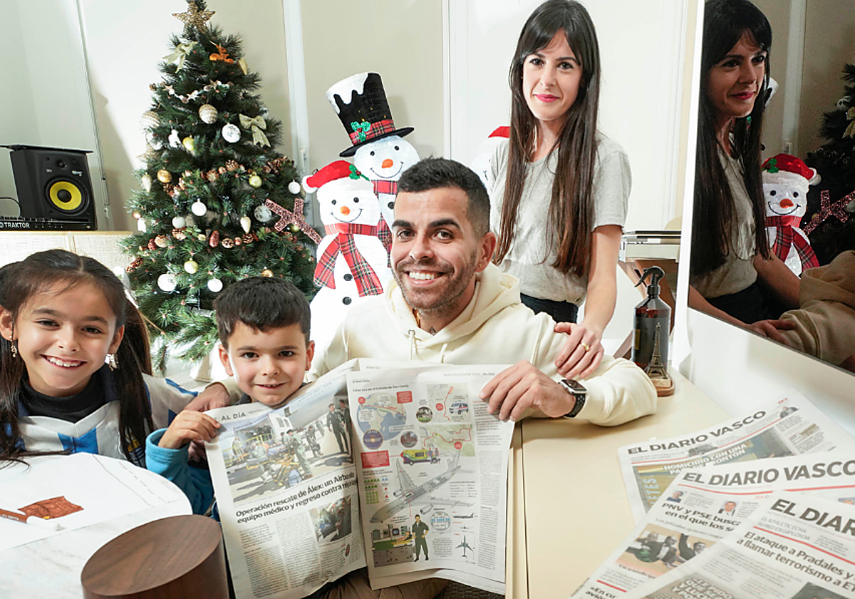 Álex y Usoa posan con sus hijos Elaia y Liam, en el salón de su casa con la decoración navideña de fondo.
