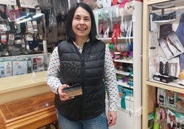 Esther Magaz en su mercería, con el premio recibido.