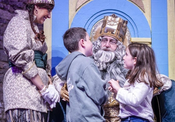 Un niño y una niña piden sus regalos al Rey Melchor.