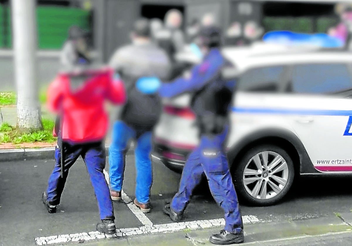 Agentes de la Ertzaintza acompañan al detenido en Bizkaia a su domicilio para efectuar un registro, en 2022