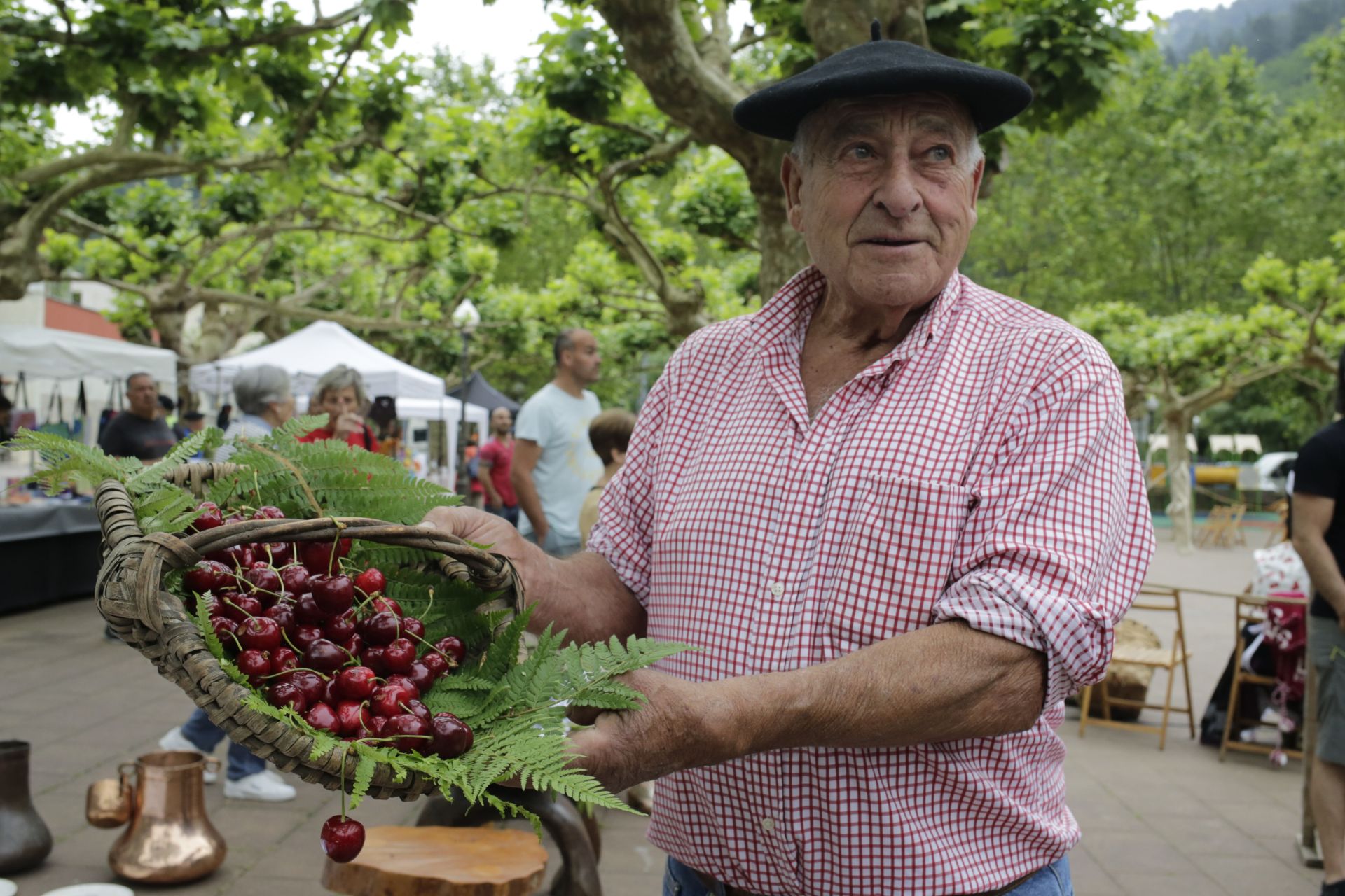 Julián mostrando unas cerezas recogidas en su huerto, en las fiestas de El Regato.