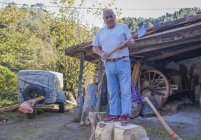 Julián Larrea en su caserío, con una de sus numerosas hachas.