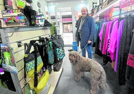 Un vecino de Getxo accede a una tienda del centro de Algorta con sus dos mascotas.