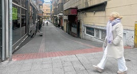 Una vecina de Las Arenas pasea junto al callejón en el que los residentes y hosteleros denuncian peleas y ruidos.