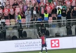 Iñigo Martínez, tras intercambiar su camiseta por la ikurriña con un aficionado del Athletic.