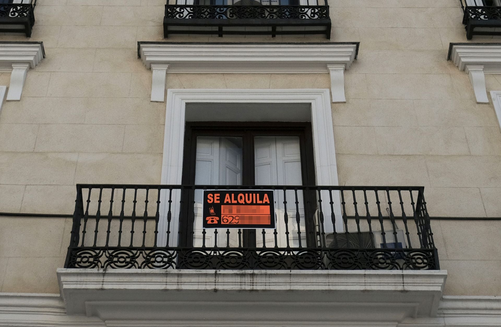 Cartel de alquiler en el balcón de una vivienda.