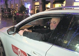 Un taxista espera la llegada de un cliente.