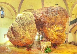 Las rocas gigantes abrazan a una pequeña imagen de San Miguel.