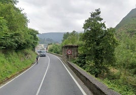 Tramo de la carretera en la que a la derecha se percibe parte del muro junto a los pilares del antiguo puente ferroviario que se usará como bidegorri.