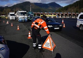 Un ertzaina prepara los elementos para un control de carretera.