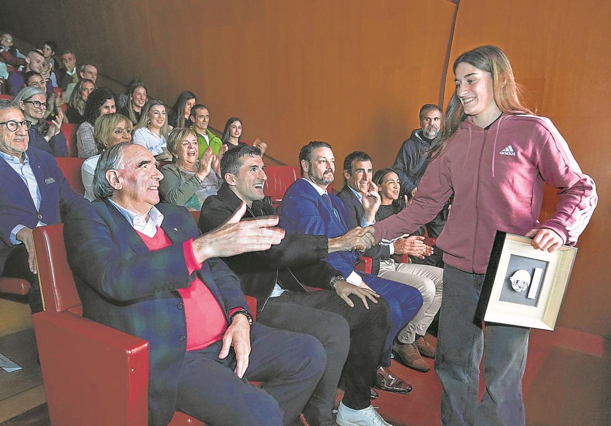 José Ángel Iribar y Dani Vivián felicitan con un choque de manos a la skater bermeotarra Naia Laso al bajar del escenario del Guggenheim con su premio.