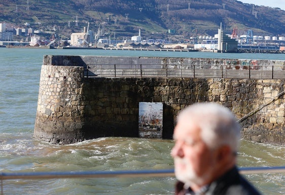 Un vecino de Getxo pasea por el Puerto Viejo de Getxo donde está colocada la obra artística del sireno