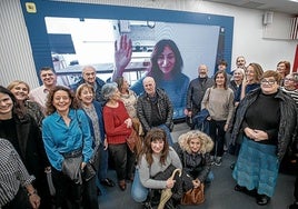 Varios participantes en el encuentro con suscriptores posan ante la pantalla, desde la que saluda Mercedes Gallego.