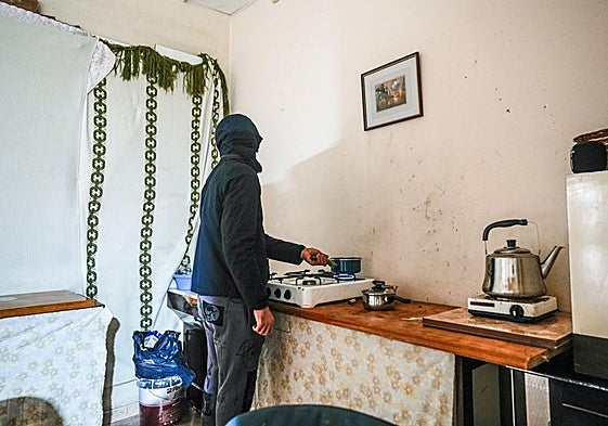 El cabeza de familia hierve unos huevos en la cocina que ha instalado en la lonja okupada de la calle Bruno Villarreal.