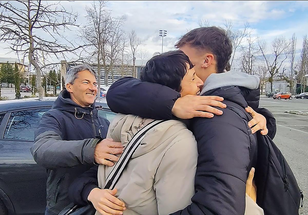 Yasmina de la Torre y Enrique Cabanes se abrazan con su hijo, Pau, en el parking de Mendizorroza.