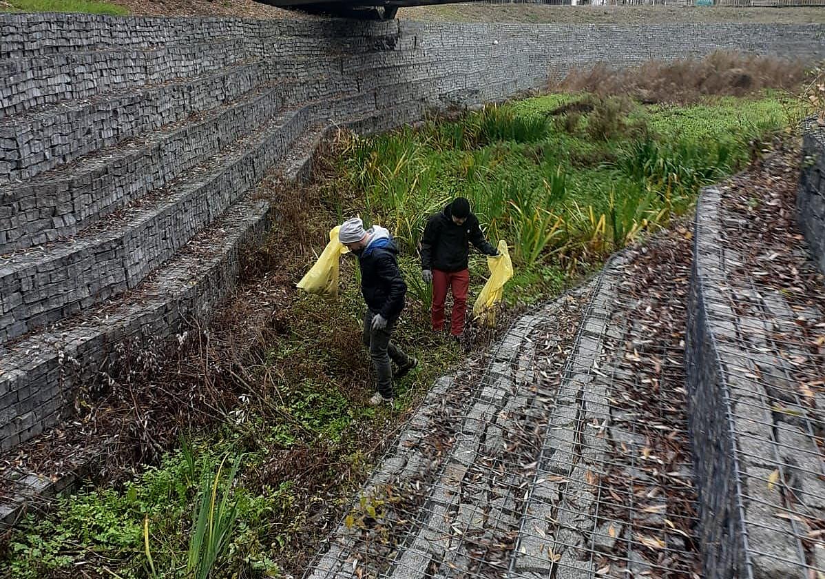 Las familias del barrio han tenido que adentrarse en el río en varias ocasiones para adecentarlo y retirar basuras.
