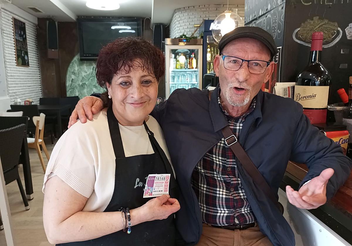 Ana Olivera, con el décimo premiado en la mano, y Antonio Ruiz celebran el segundo premio del sorteo de San Valentín de la Lotería Nacional