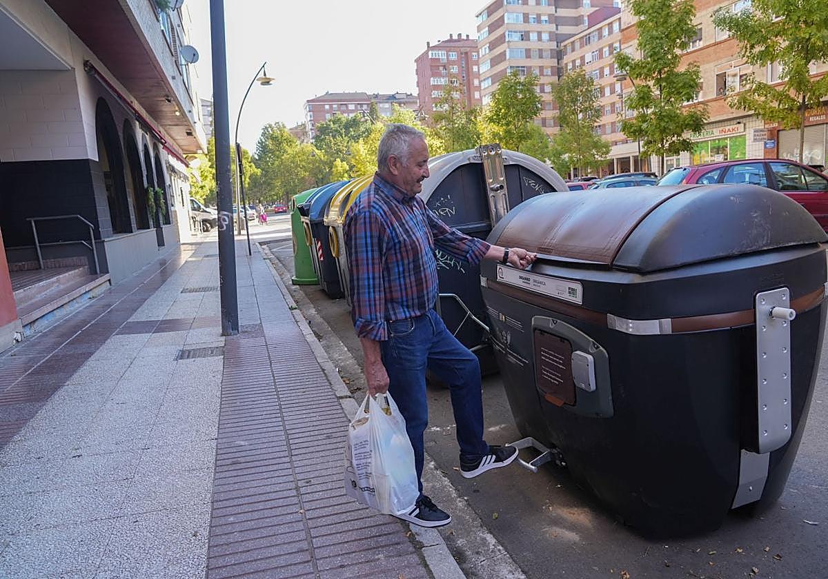 Un ciudadano deposita los residuos en el contenedor marrón.
