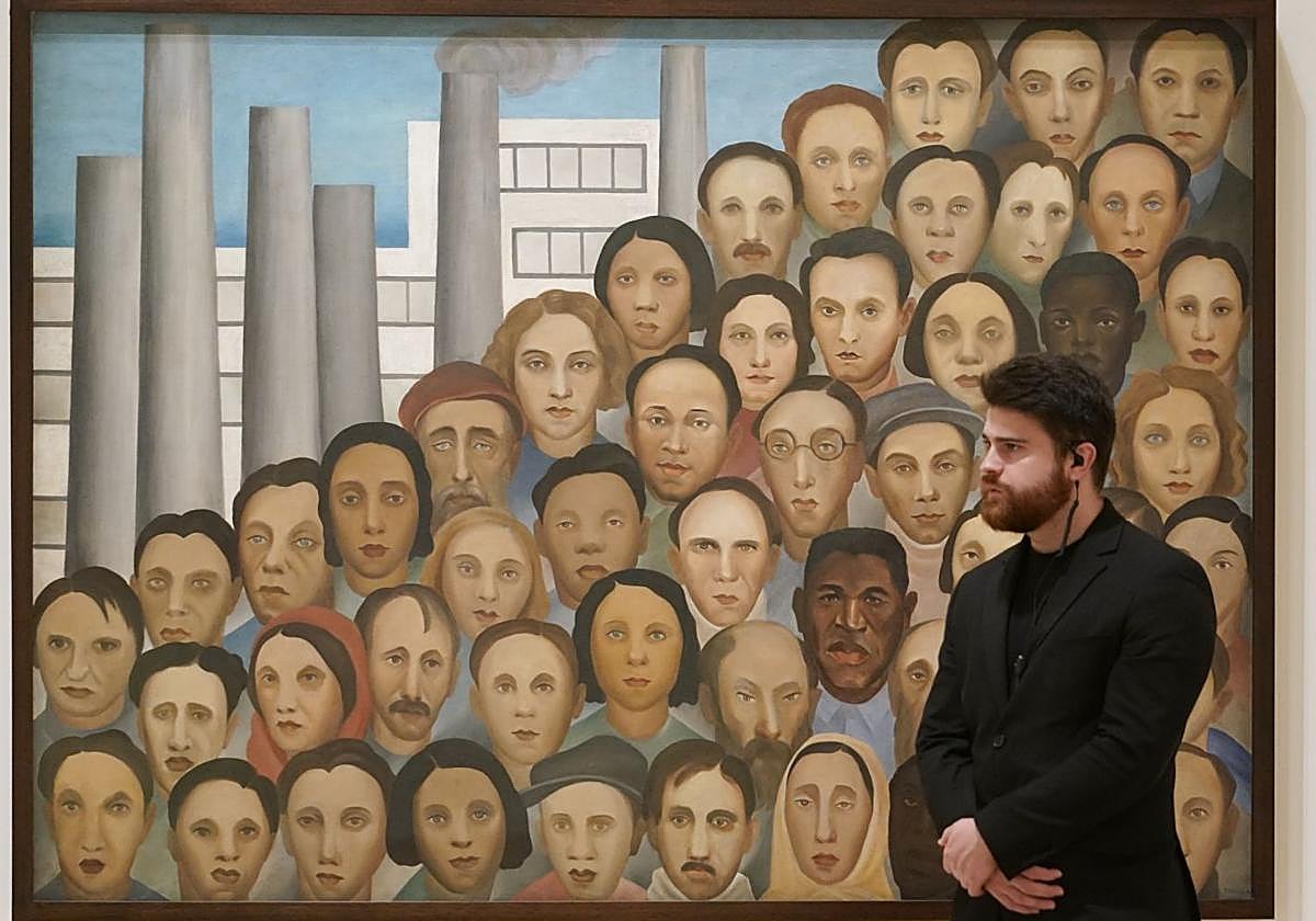 Un empleado del Guggenheim posa delante de la pieza 'Obreros' (1933).